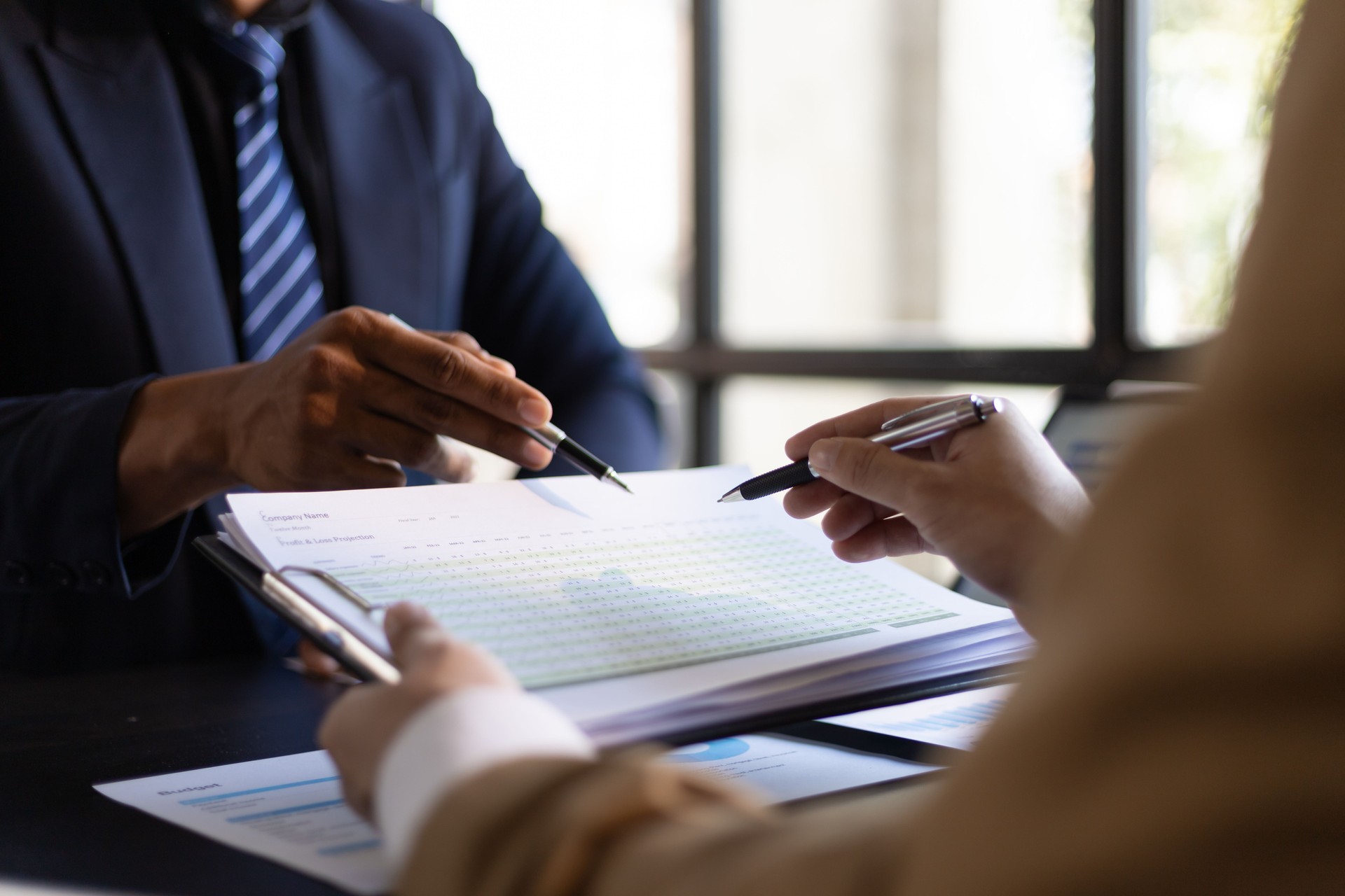 Businessmen meeting to discuss financial advisors audit accounting and analyzing financial figures. Businessman are discussing budget analysis, profits, income, expenses and financial planning.